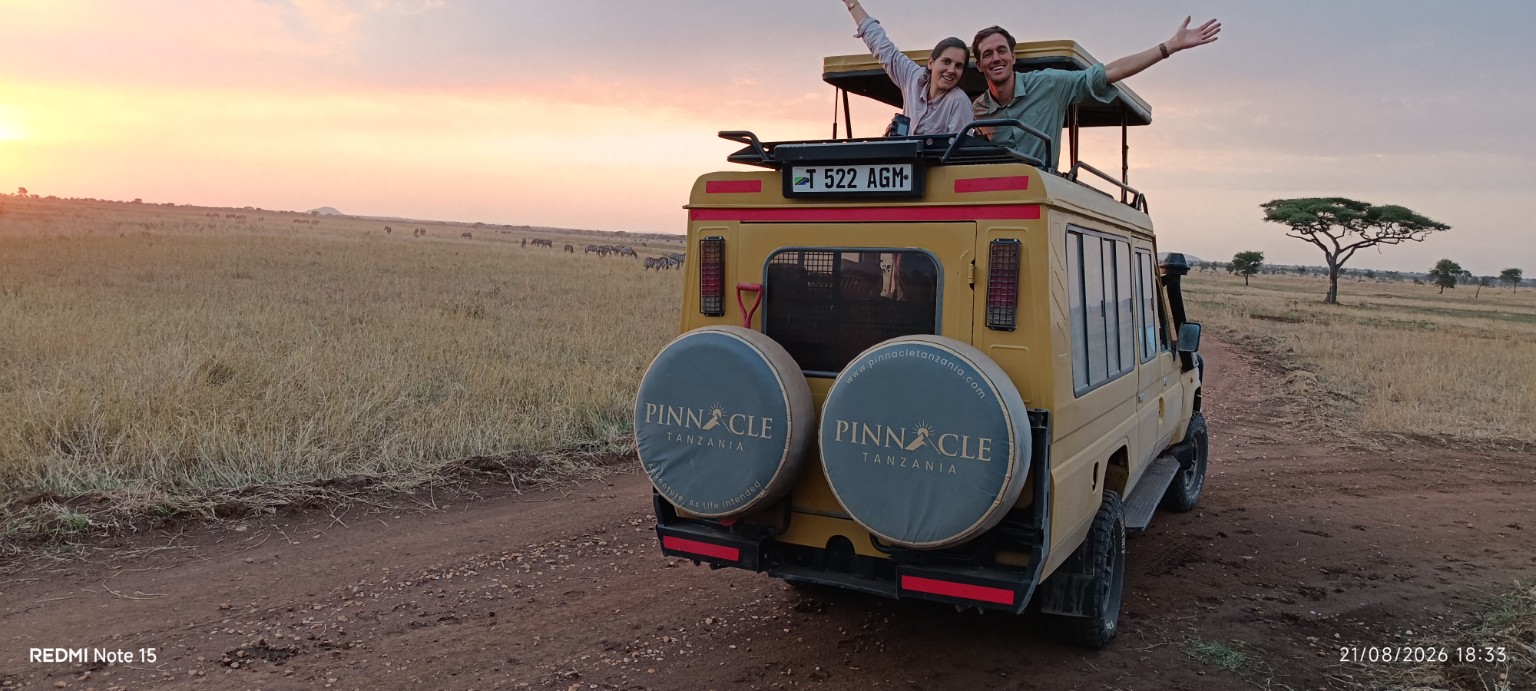 Travellers enjoying sunset from a Pinnacle Tanzania safari vehicle